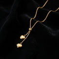 Dainty Gold Heart Lariat Necklace - Product on black velvet background