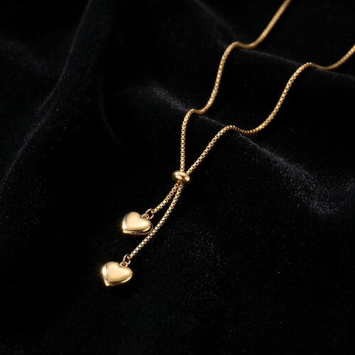 Dainty Gold Heart Lariat Necklace - Product on black velvet background