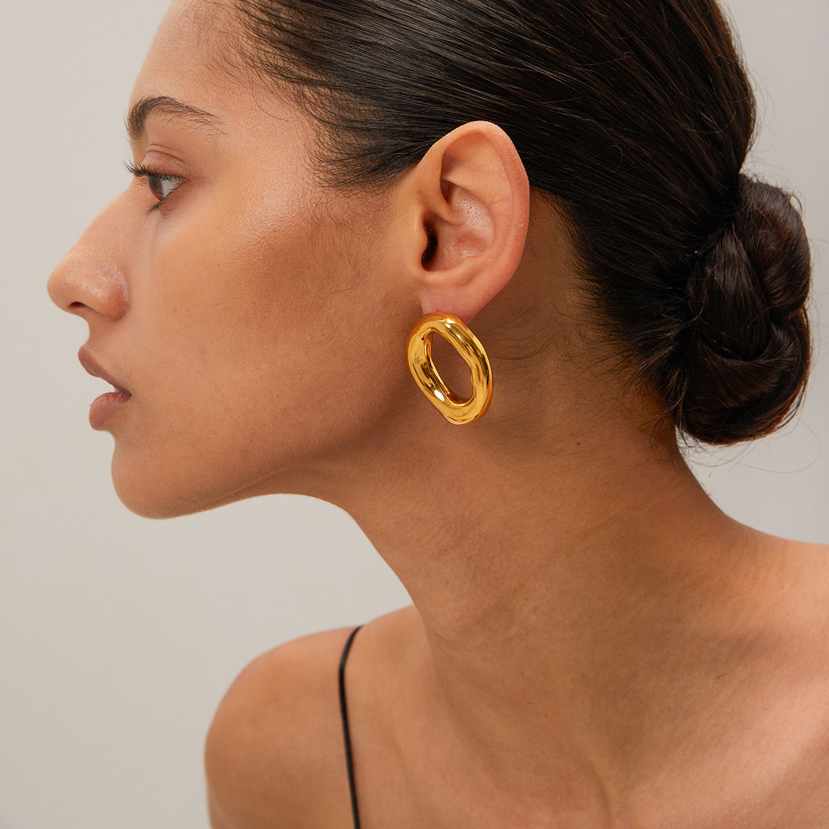 Woman wearing Sculpted Gold Oval Hoop Earrings